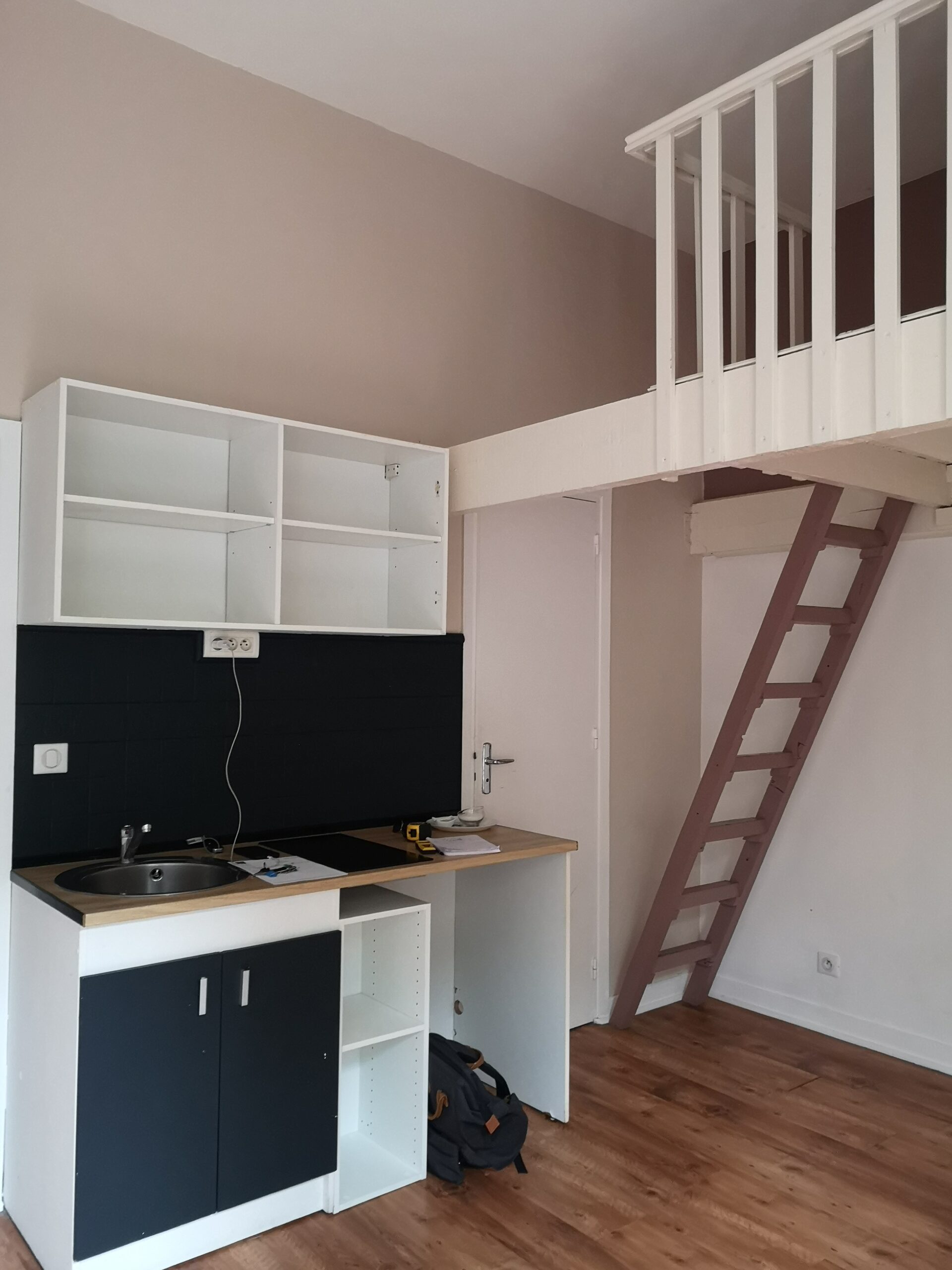 Coin repas du studio mezzanine avant aménagement, la crédence et les portes sont foncées